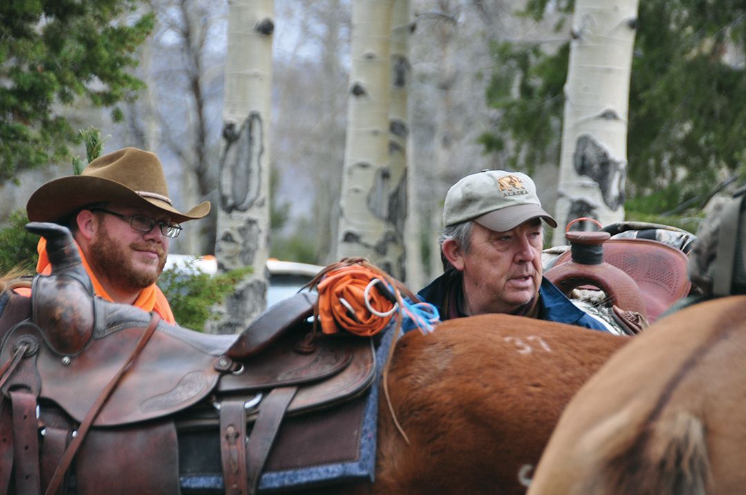 These hunters are checking the rigging on a saddled mount. Pay attention to the rigging on your horse so problems can be identified if they arise.